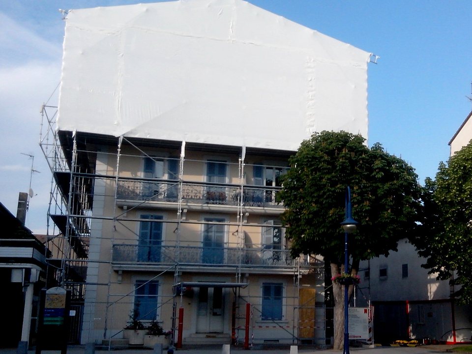 Vollständig eingehaustes Gebäude während einer Asbestsanierung an der Fassade
